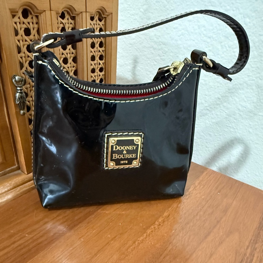 Authentic Dooney & Bourke black patent leather Bitsy Bag.